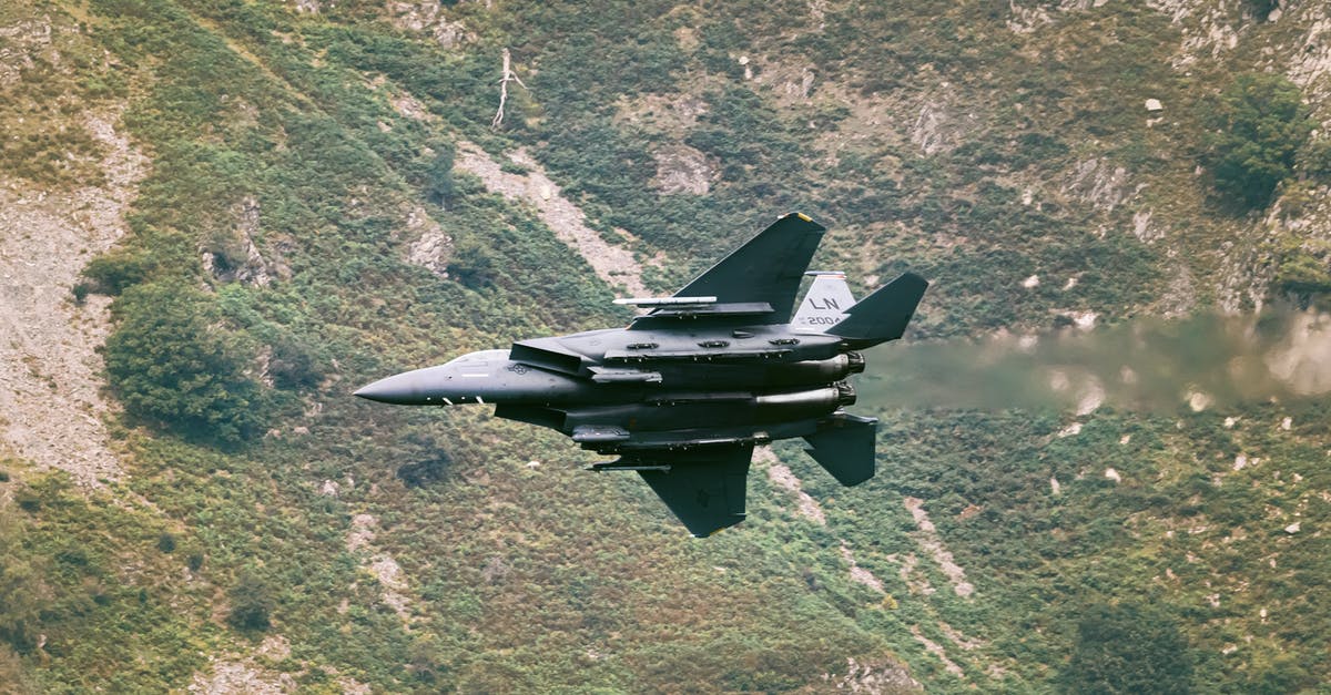 Safest way to transport a laptop during flight - Superiority fighter flying over valley