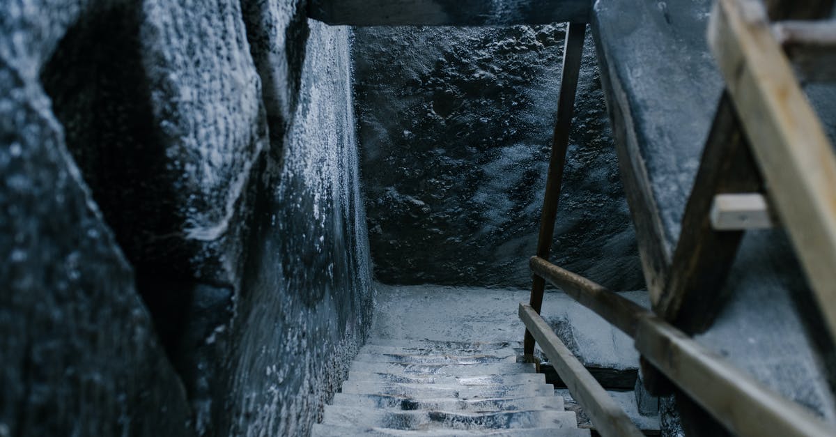 Salt mines in Poland -- differences between Wieliczka and Bochnia? - From above of aged stone stairway covered with salt in ancient cave with shabby walls and wooden railings in Registry Chamber of Salina Turda mine