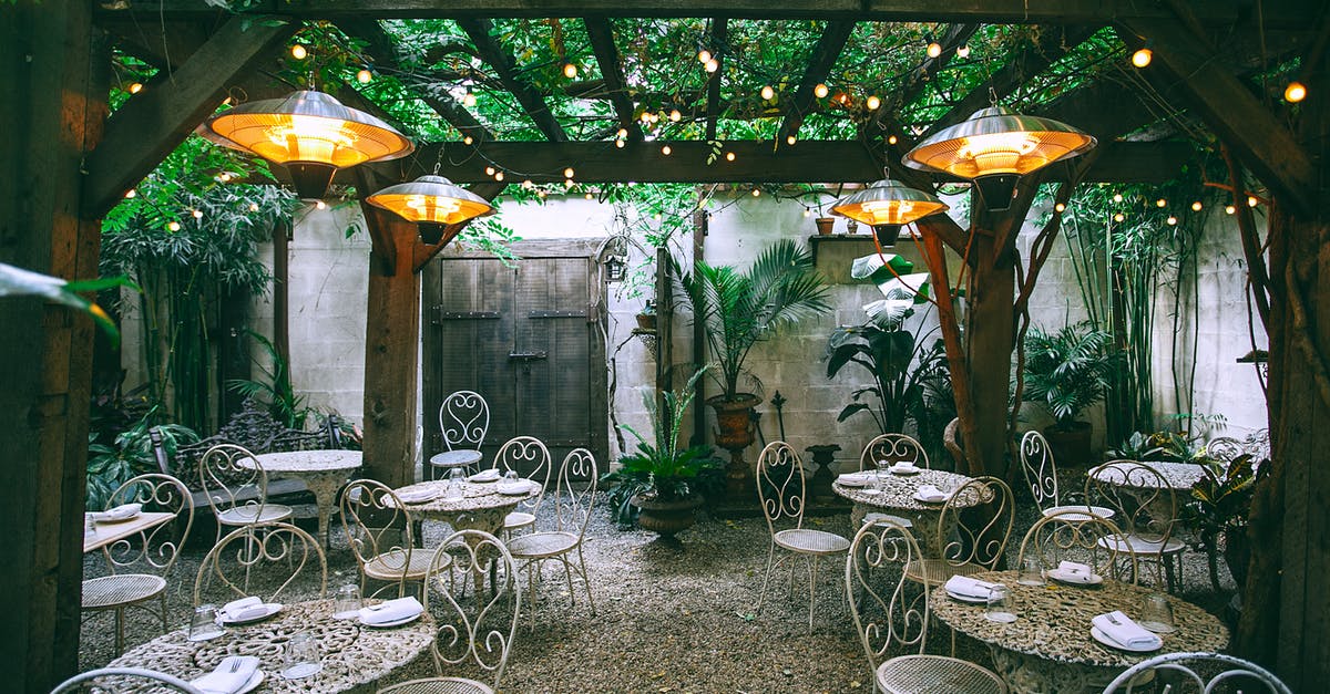 Scenic restaurant overlooking Washington DC - Cafe with setting on ornamental tables near chairs under decorative lamps in backyard on summer day