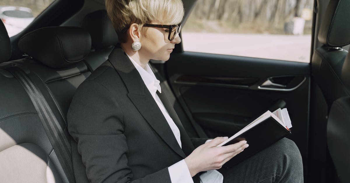 Scheduling a ride with Uber - Focused woman checking planner information in car