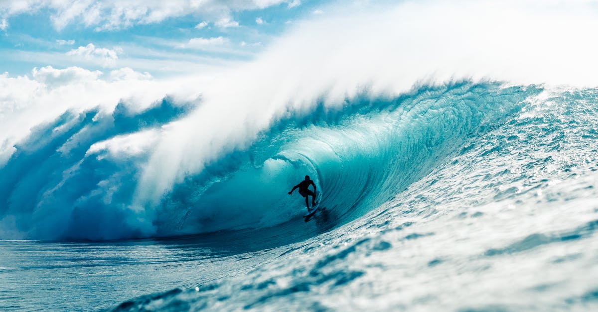 Scheduling a ride with Uber - Man riding surfboard in wavy ocean