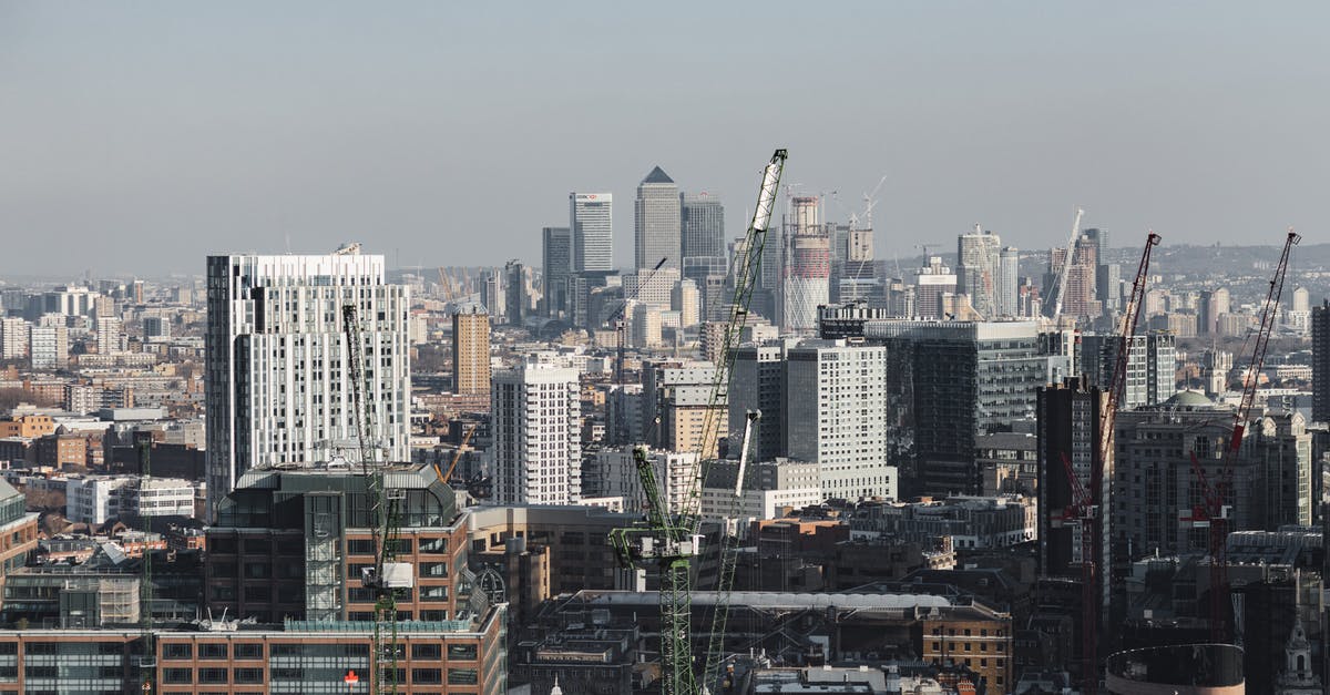 Schengen Area to UK to Canada to USA - Scenic cityscape of London district with contemporary multistory buildings and crane towers under cloudy sky in daylight