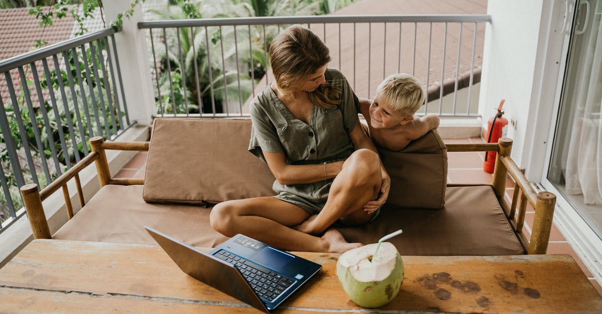 schengen mother and child hotel reservations - Man and Woman Sitting on Brown Couch Using Macbook