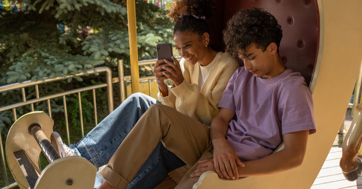 Schengen Visa - Date of Departure after first intended stay - Teenage couple sitting in carousel seat and girl taking selfie