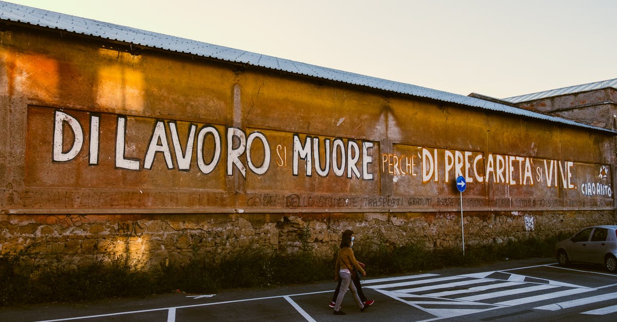 Schengen visa as a spouse of an Italian citizen - Anonymous citizens strolling on road against building with inscription