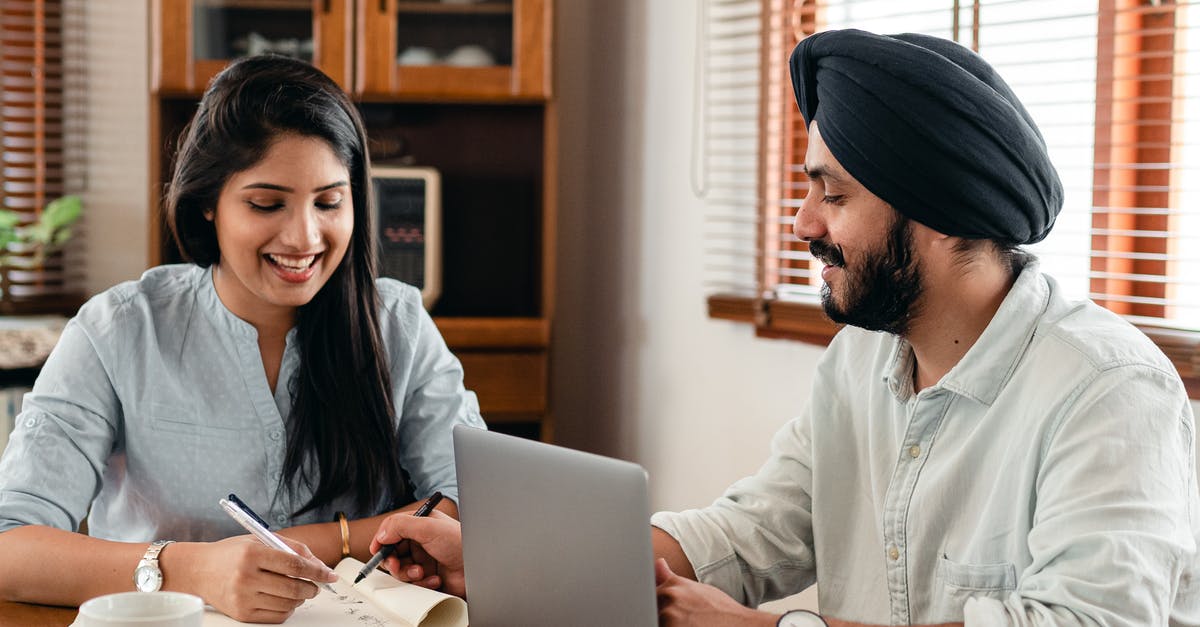 Schengen visa for an Indian student in Ireland - Happy Indian couple using laptop while doing homework together