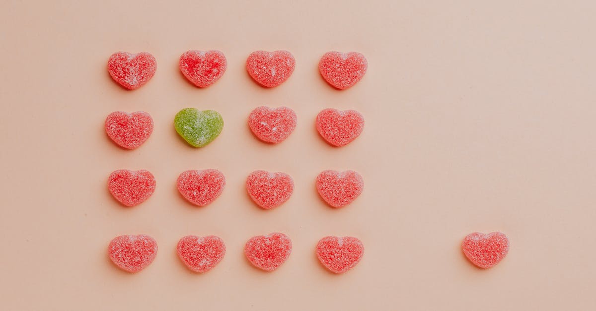 Schengen visa single entry from Hungary - Top view of delicious sprinkled jelly sweets composed in lines with one candy aside on pink backdrop in candy shop