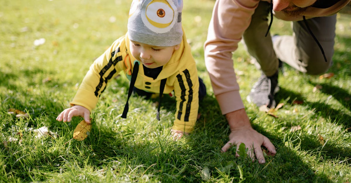 Schengen visa sponsored by my father - Child in Yellow and Black Stripe Long Sleeve Shirt and Gray Cap on Green Grass Field