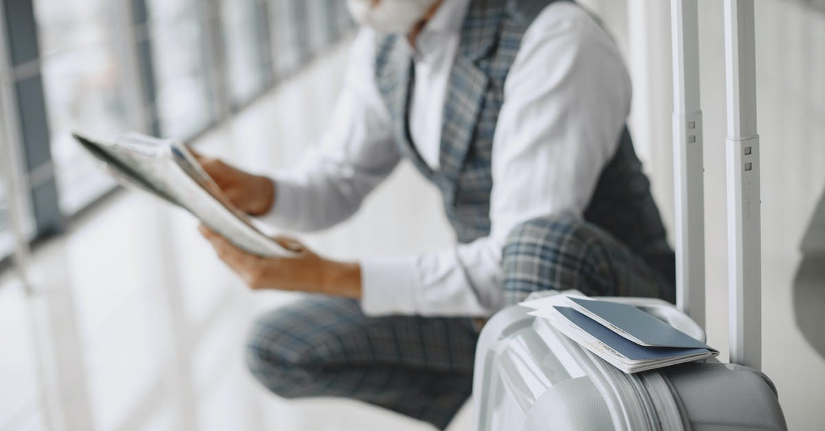 Schengen visa: Travel dates slightly mismatch with available documents - A Man Holding a Paper Sitting Near His Luggage