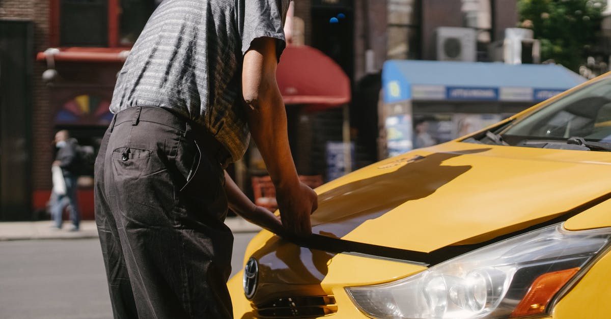 Search engine for stop over possibilites - Ethnic driver opening taxi hood on street