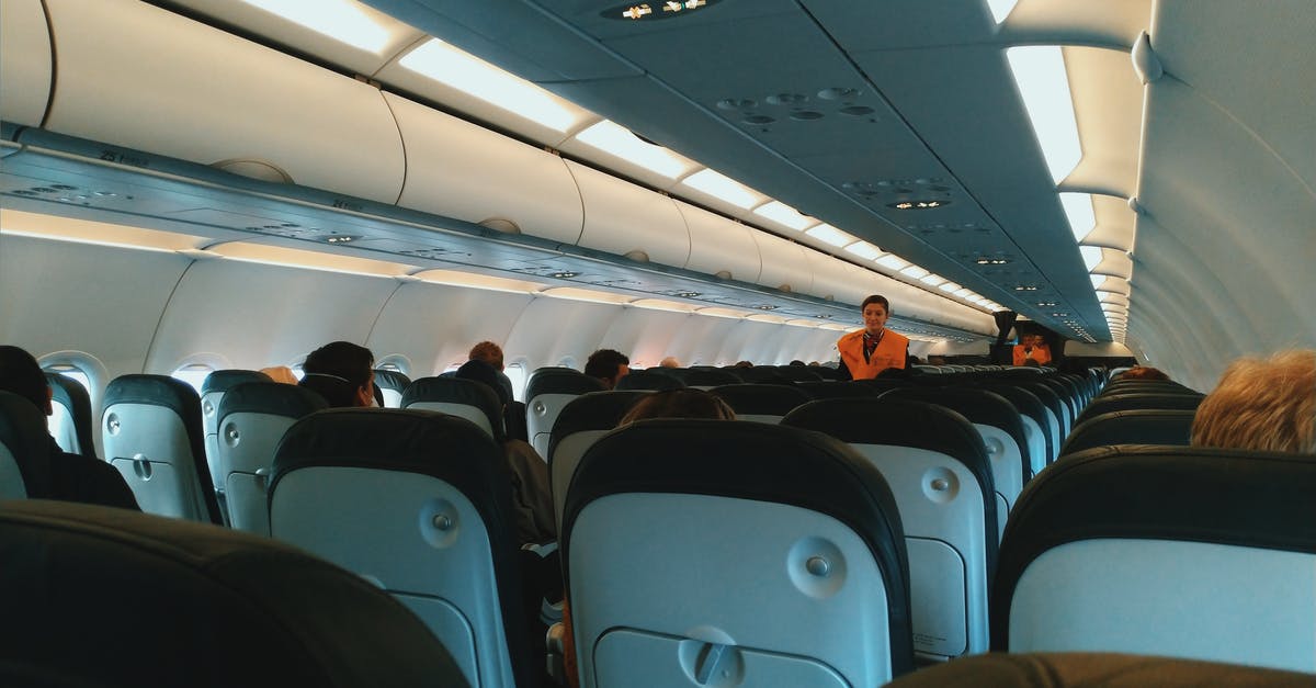 Seat change on Easy Jet - Inside of modern airplane cabin with passengers sitting on comfortable seats and cabin crew standing at passageway