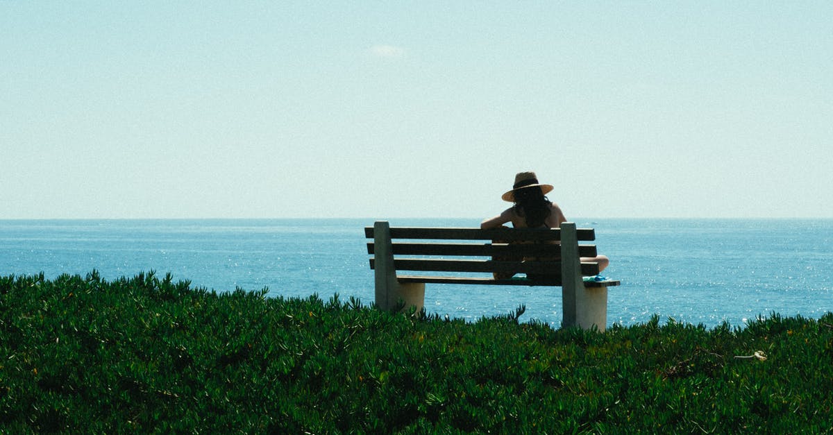 Security issues for a girl travelling solo around Europe [closed] - Woman Sitting on Bench on Grass Shore during Day