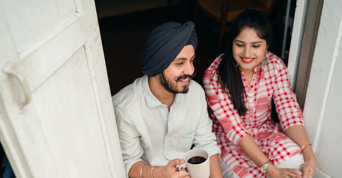 Self-isolate if my home country rises above threshold while I'm in Latvia? - From above of smiling young Indian man with black coffee and woman in bright checkered shirt having pleasant conversation while sitting at threshold Self-isolate if my home country rises above threshold while I'm in Latvia? - From above of smiling young Indian man with black coffee and woman in bright checkered shirt having pleasant conversation while sitting at threshold