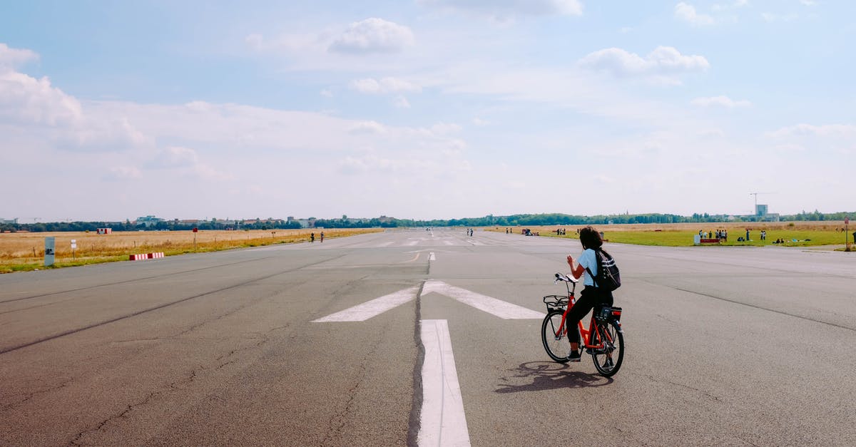 Sending my bike cover from airport A to airport B // pick-up 9 days later - Man Riding Red Bicycle