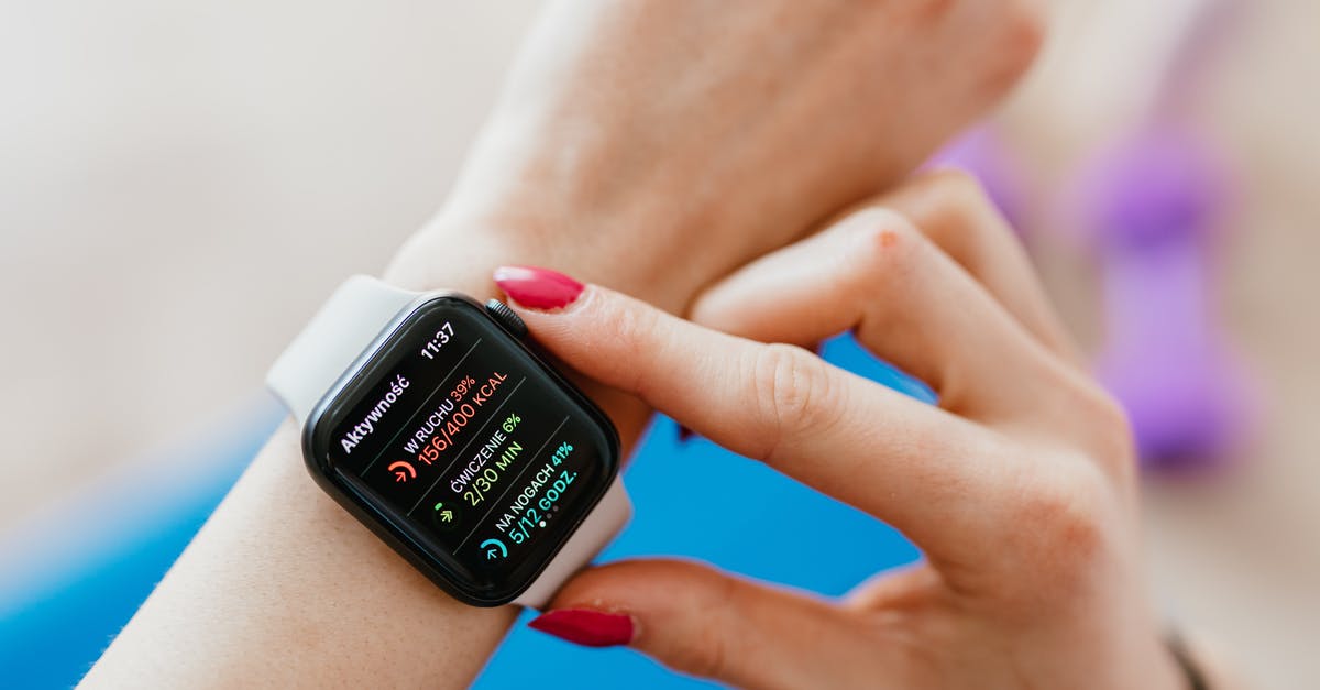 Sending my passport as part of my Canada Visa Application - Unrecognizable female with manicure checking smartwatch on hand while sitting on yoga mat