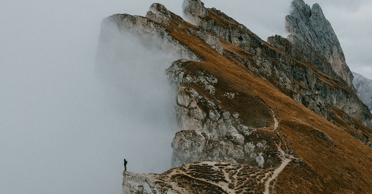 September in Dolomites - Photo of Person Standing on Cliff Edge