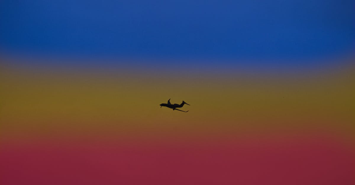 Shipping gear from Bangkok to Europe - Silhouette of airplane landing gear transporting people or goods soaring over bright colorful sky