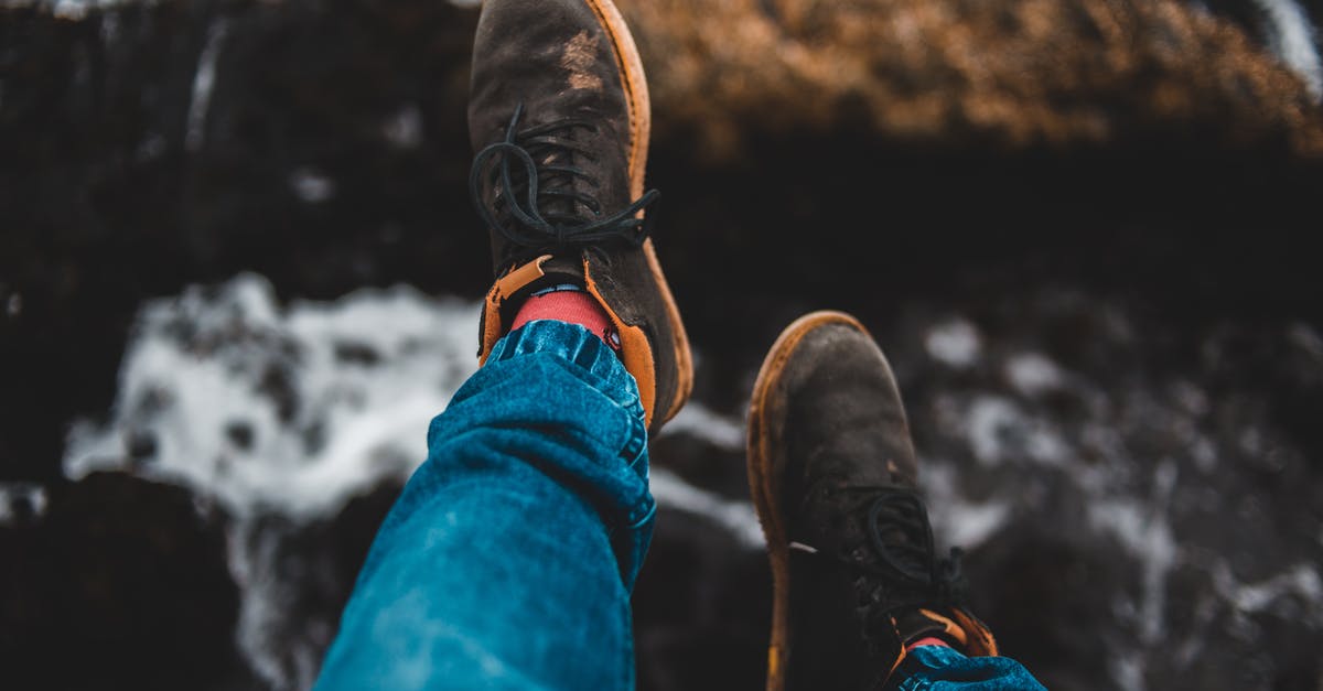 Shoes to wear for December trip to Europe [closed] - Crop traveler in casual sneakers resting on mount above sea