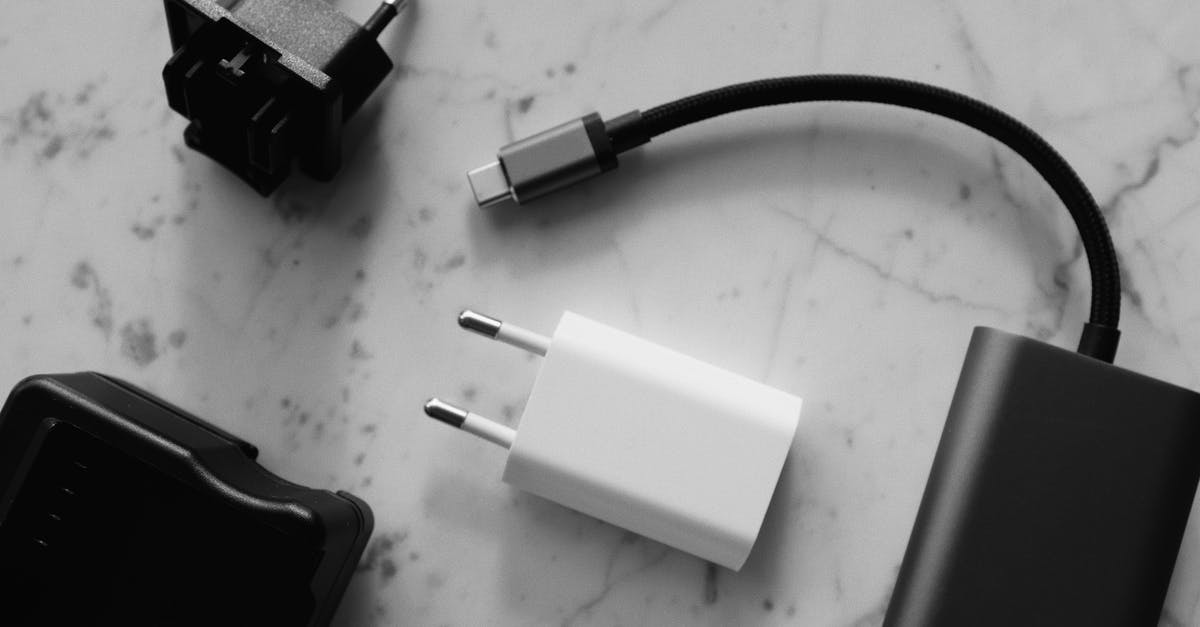 Short Connection - Composition of various modern charging units with adapter and small black external battery with short cable placed on white marble table