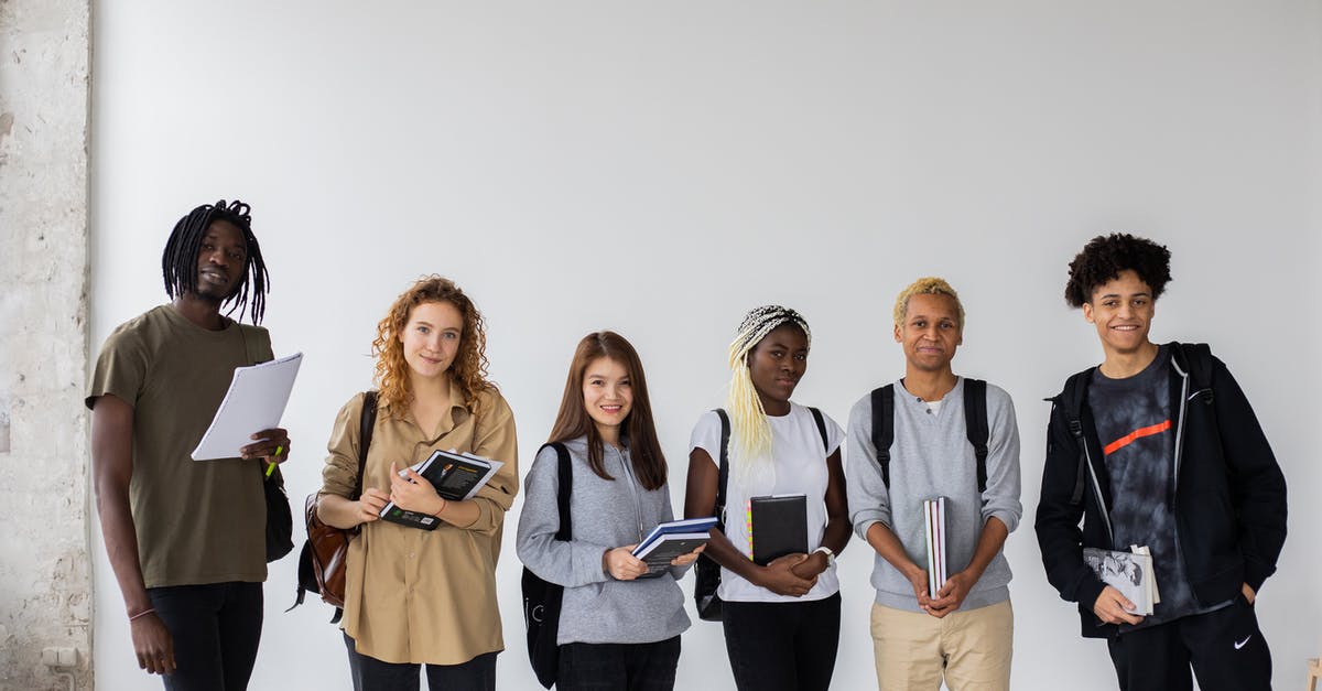 Short term schengen visa tourism vs course study ratio - Group of diverse young multiracial classmates with notebooks and textbooks and backpacks smiling at camera