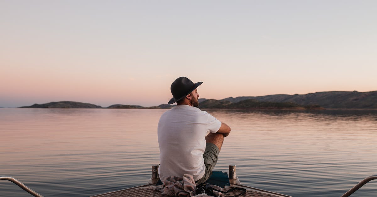 Short Term Tourist Visa Refusal [duplicate] - Back view of unrecognizable man in casual clothes and hat sitting on boat near photo camera while admiring peaceful sea under cloudless sky