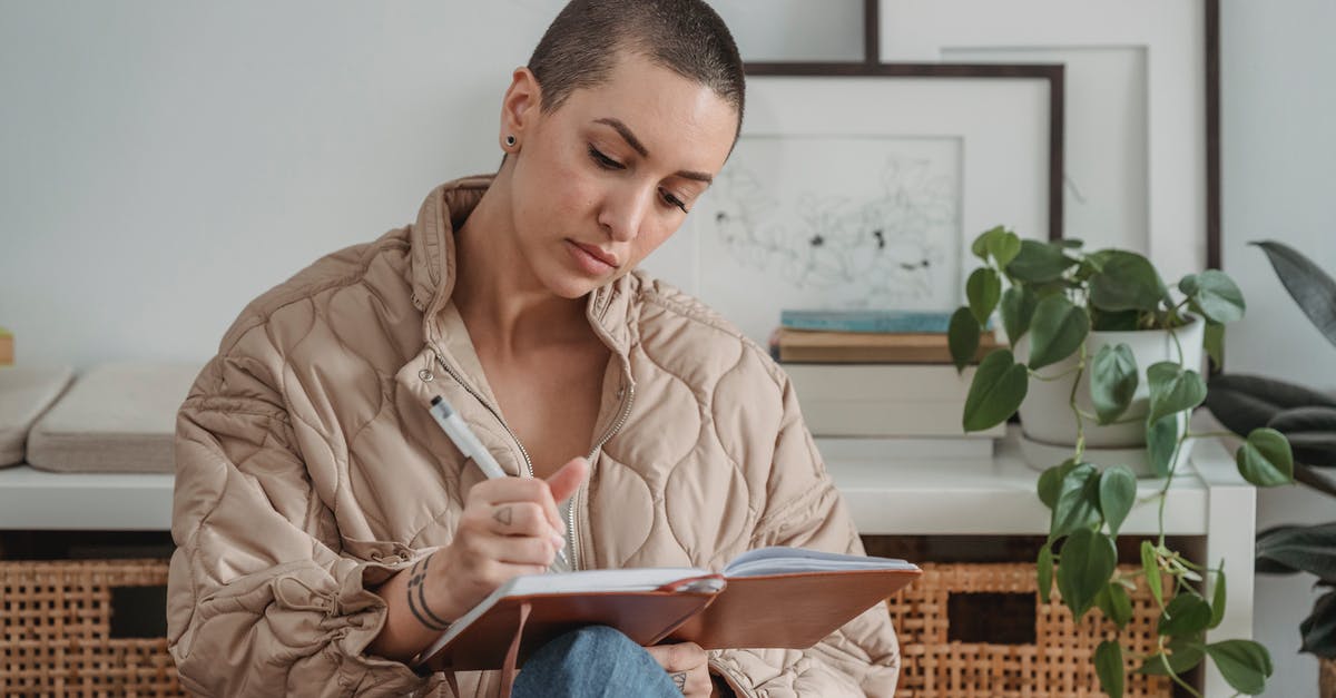 Short-term study visa UK - Pensive young female with short hairstyle writing in notebook while sitting in light living room