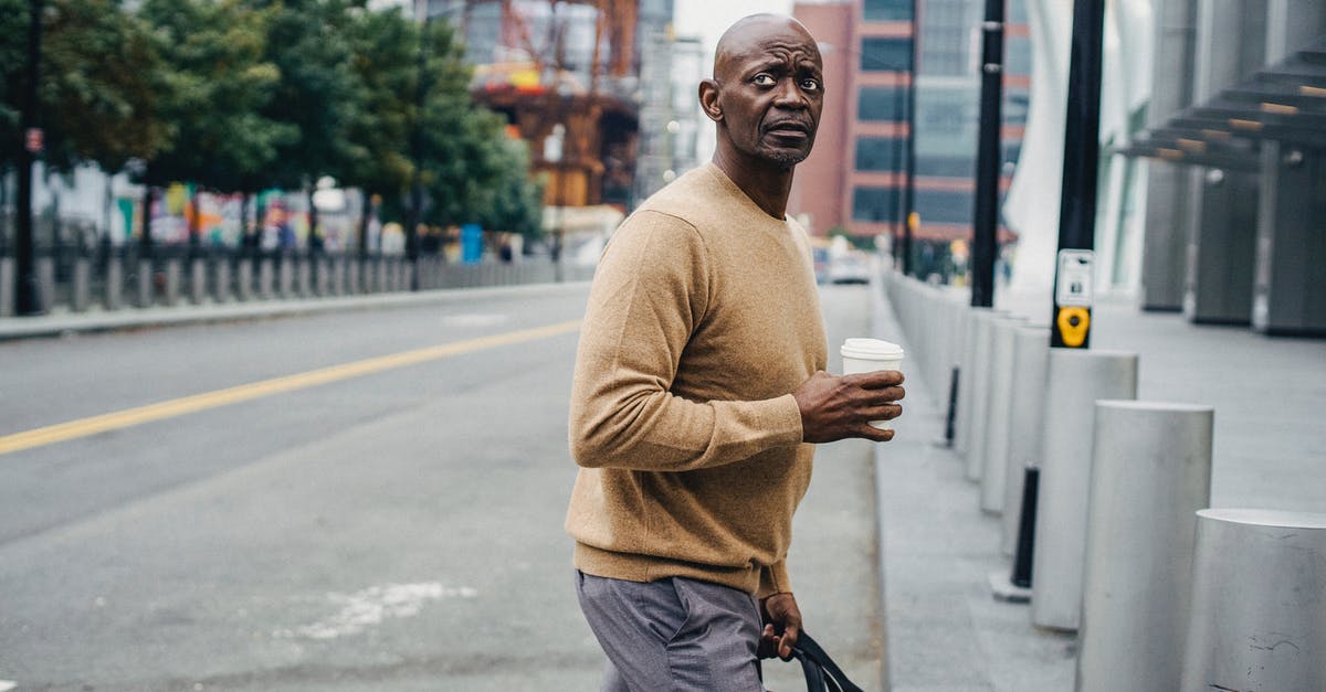 Should a student carry a sleeping bag with himself when going abroad? [closed] - Formal black man with coffee on crosswalk