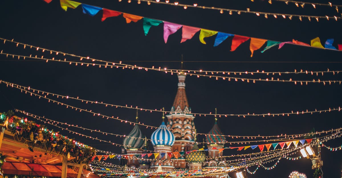 Should I avoid providing a copy of my passport to a third party to secure a visa to travel to Russia for a conference? - Strings of illuminated garlands hanging over holiday market on background of majestic cathedral