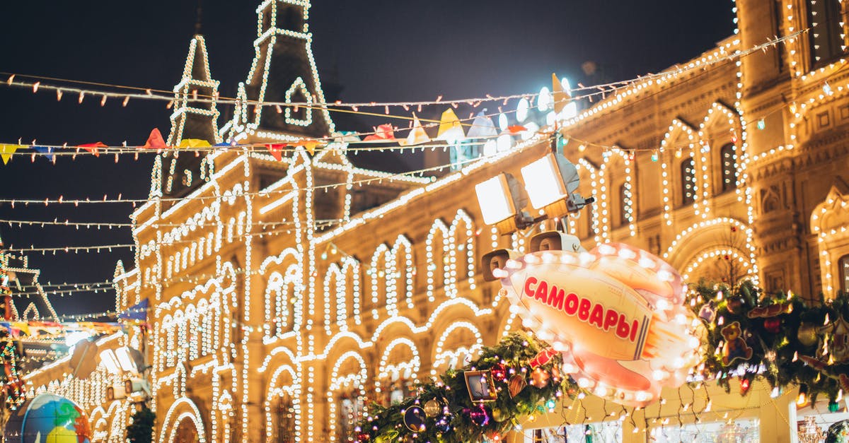 Should I avoid providing a copy of my passport to a third party to secure a visa to travel to Russia for a conference? - Low angle of exterior of old building decorated with small round white lamps during Christmas holiday in night city under cloudy dark sky