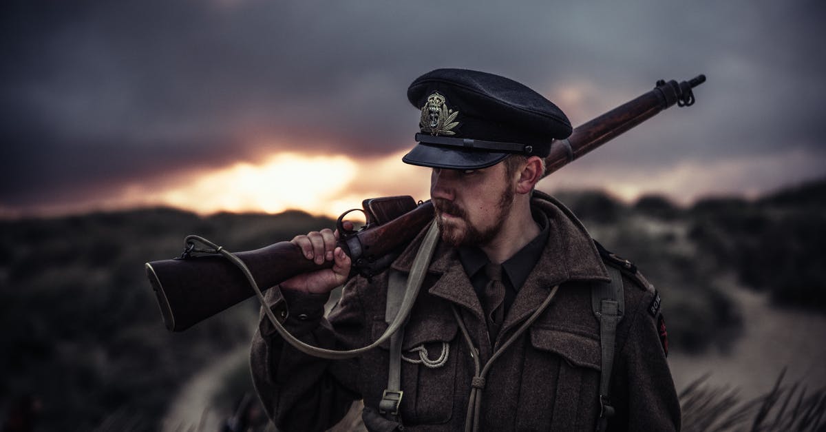 Should I buy a weapon if travelling to dangerous countries [closed] - Close-Up Photography of a Man Holding Rifle