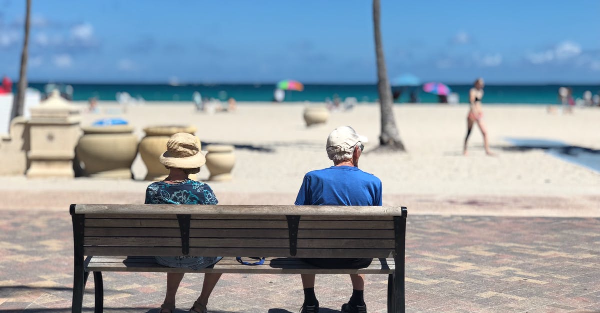 Should I cancel my Miami vacation? [closed] - Man and Woman Sitting on Brown Wooden Bench