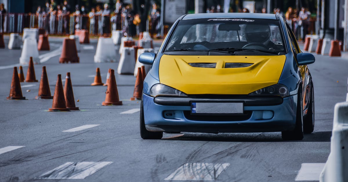 Should I contest this right on red traffic violation [closed] - Faceless driver in contemporary car with yellow hood driving along city road between barriers close to viewers on sunny day