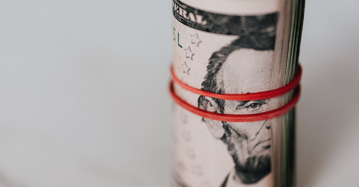 Should I deposit money back into my account when waiting for a visa - Roll of american dollars tightened with red band Should I deposit money back into my account when waiting for a visa - Roll of american dollars tightened with red band
