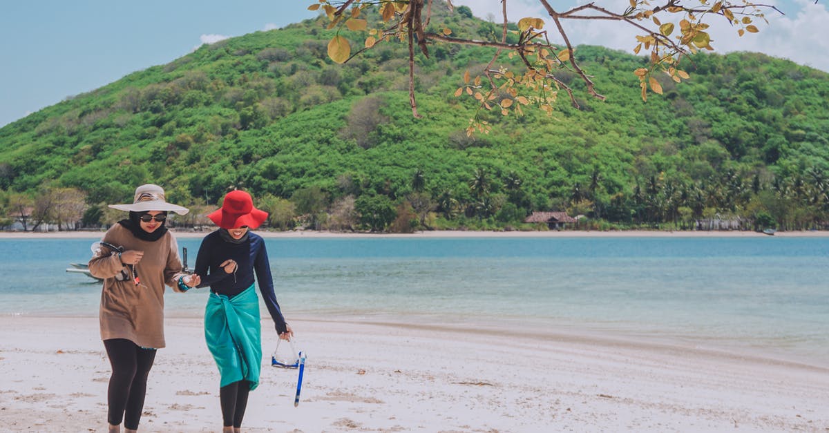 Should I get vaccination before travelling to Lombok (Indonesia) - Photo of Two Women Walking on Seashore