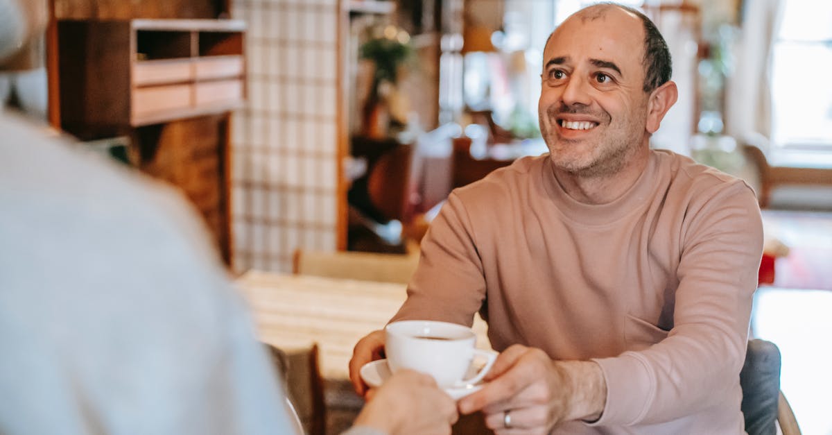 Should I take my own coffee to Japan? - Unrecognizable woman giving coffee cup to positive ethnic husband