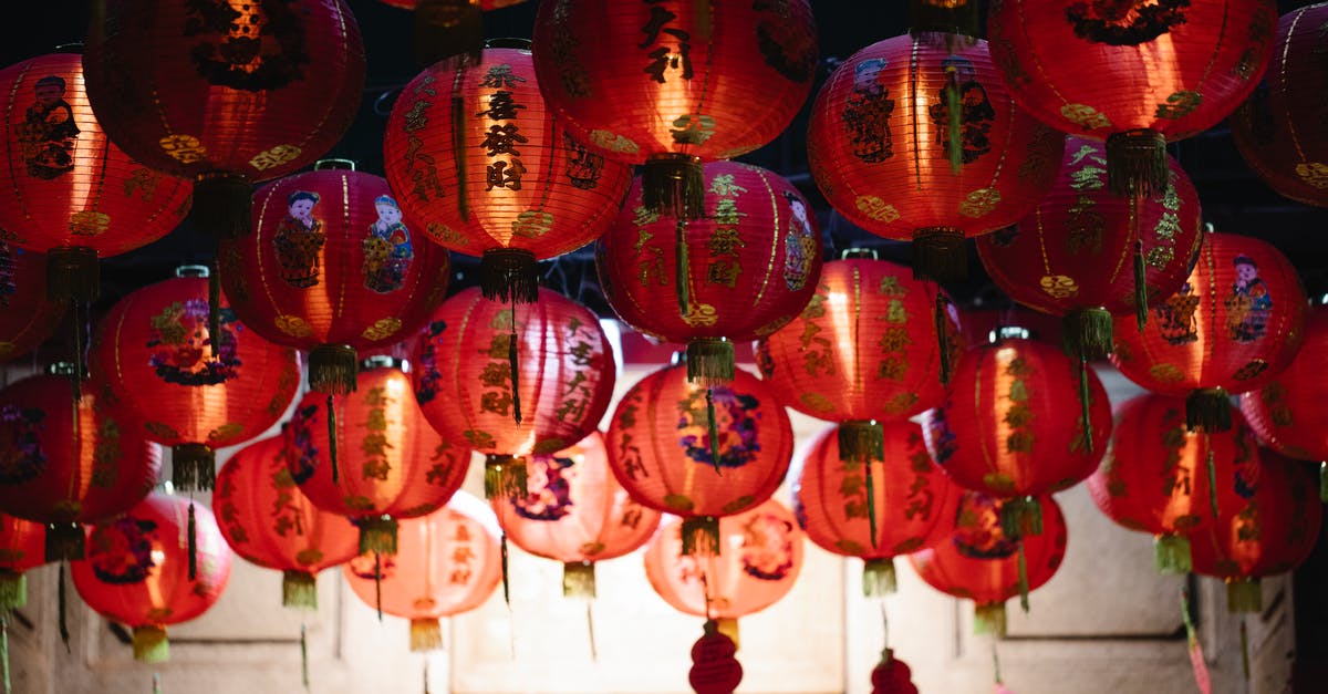 Singapore events and attractions open at Chinese New Year - From below of many red rice paper lanterns with golden hieroglyphs hanging on street during celebration of Chinese Spring Festival