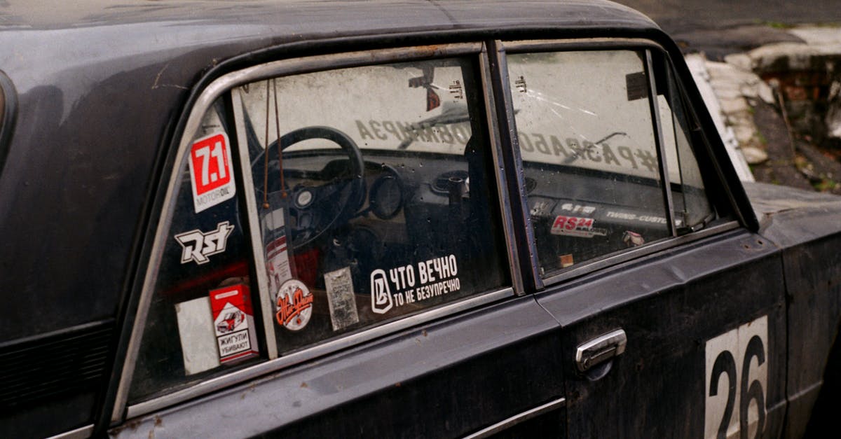 Singapore visa accidentally issued with old passport number. Can I still travel? - Retro automobile with colorful stickers with numbers and titles on street in town