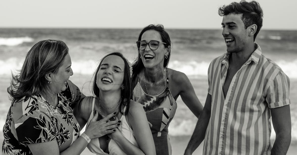 Single parent travelling with minors [closed] - Black and white happy family standing together and laughing happily while reacting on news during vacation on beach