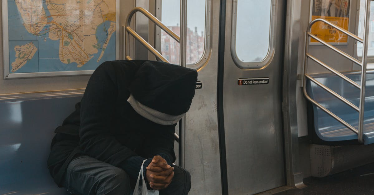 Single train tickets that cannot be bought alone - Person in Black Hoodie Sitting on Train Bench