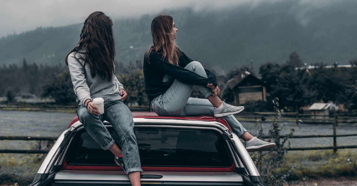 Single trip to conferences in two Schengen countries with one visa? - Two Women Sitting on Vehicle Roofs