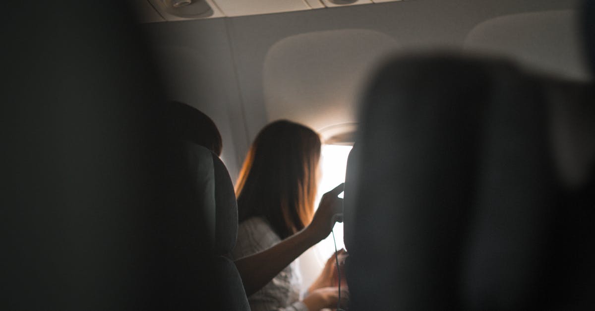 Sit at left or right window when flying into and out of Hong Kong HKG - Woman Riding in Airplane Near Window Sit at left or right window when flying into and out of Hong Kong HKG - Woman Riding in Airplane Near Window