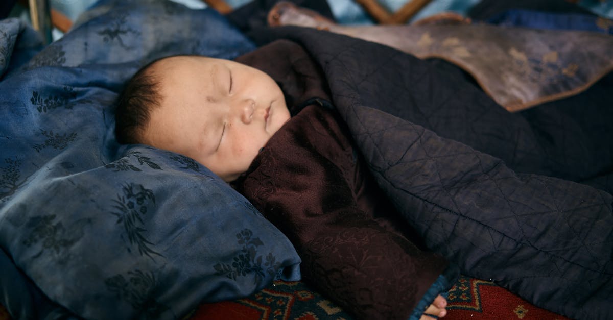 Sleeping overnight at Reagan National (DCA) airport - Side view of ethnic baby in warm national clothes sleeping under blanket on place covered by carpet