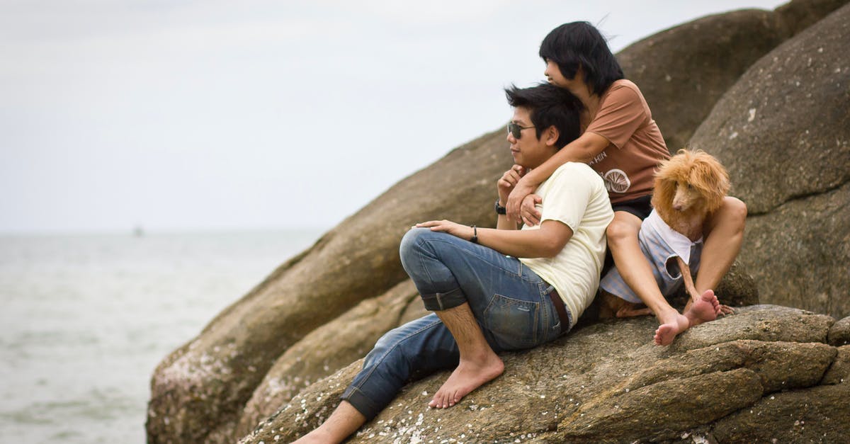 Slightly Overstaying In Thailand Due To miss count (31 days) [duplicate] - Couple Sitting on Boulder with Their Pet Dog