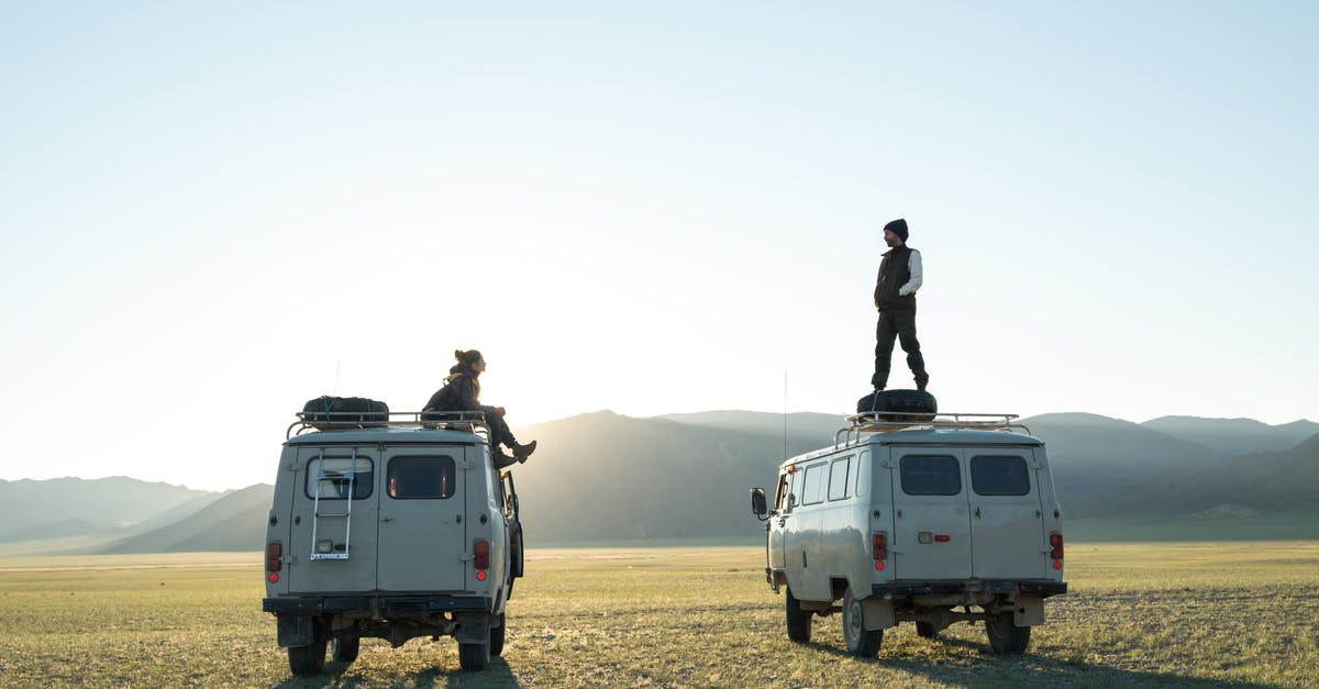 Small group tour operator for Southern USA trip - Wandering tourists standing on minibuses traveling across plain and admiring dawn over hills during vacation tour