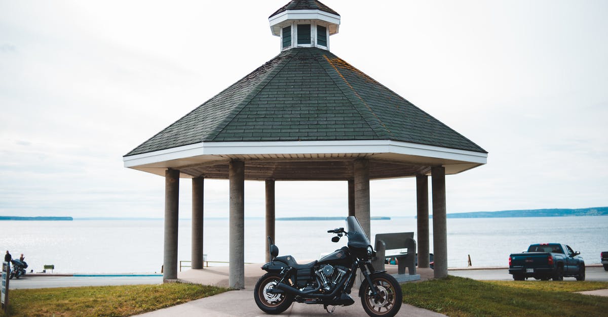 South Lake Tahoe travel by Public transport - Cloudless clear sky over black classical motorcycle parked on road to tall rotunda on shore of big lake