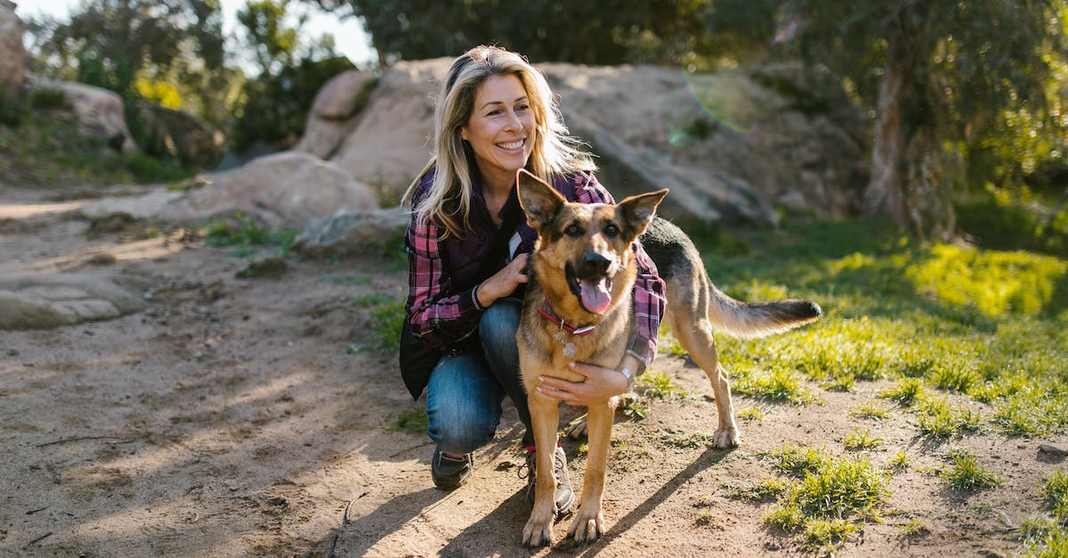 Southern California nature day trips? - Woman in Purple Long Sleeve Shirt and Blue Denim Jeans Sitting Beside Brown Dog