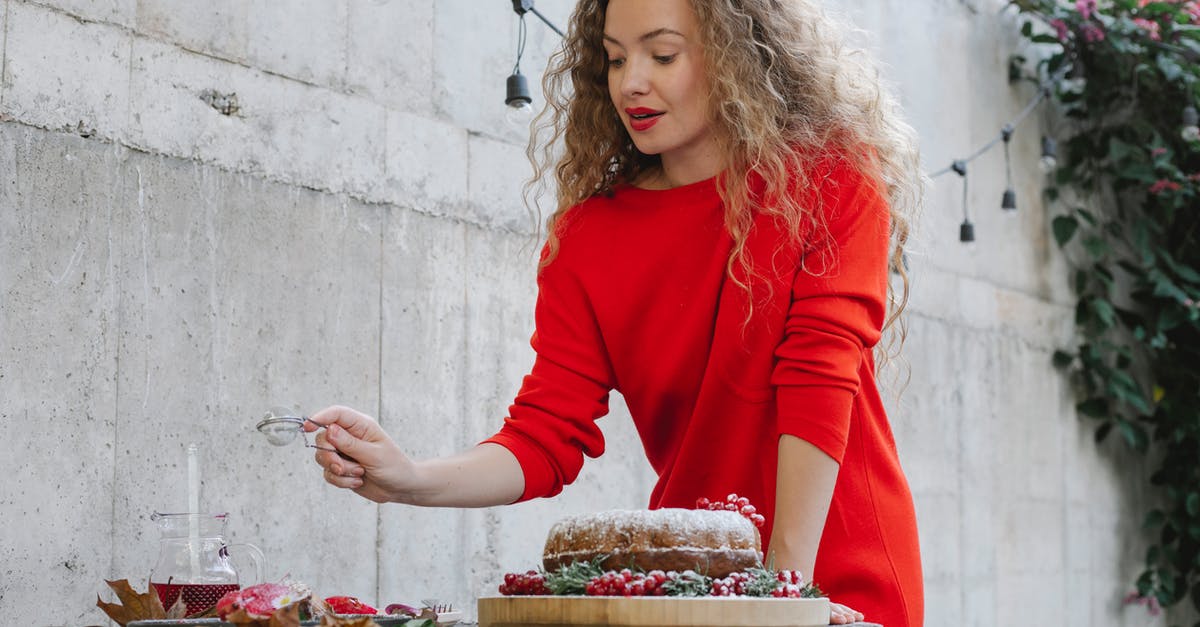 Special meals on long-haul flights - Elegant young female in bright red dress serving sweet delicious desserts on table in yard