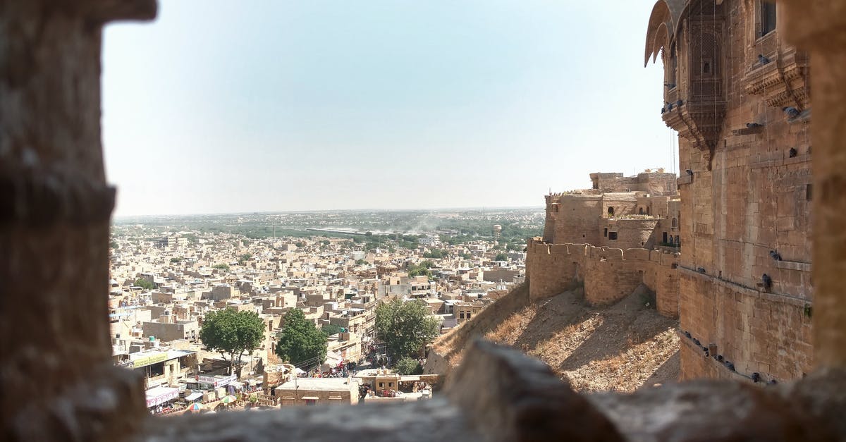 St. Angelo's fort tomb stone - Distant ancient stone buildings of aged town with wall of medieval fort in India