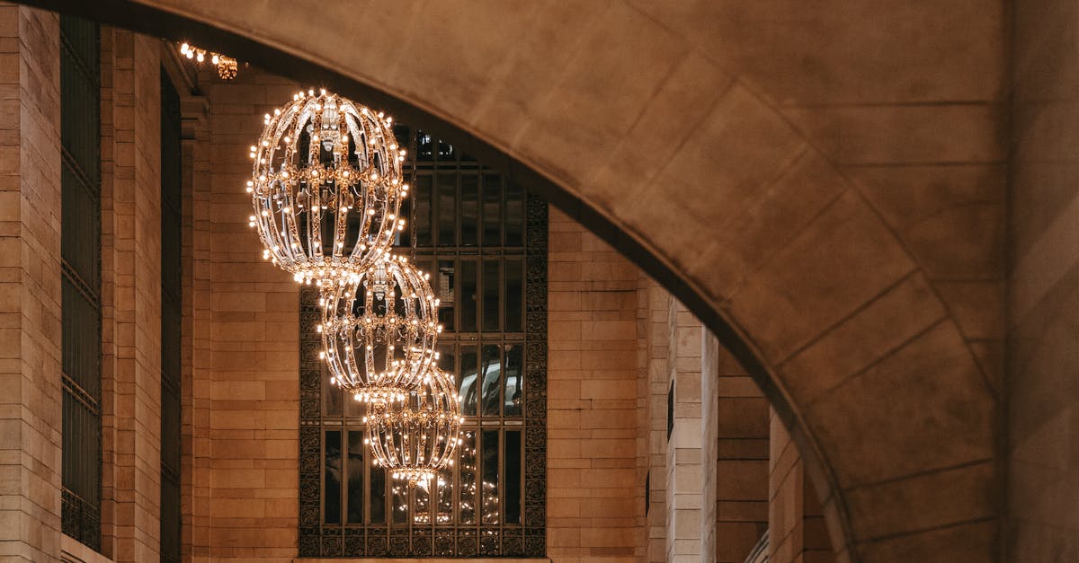 Stairwell inside The Met Manhattan - Majestic glossy lamps hanging on high ceiling in hallway