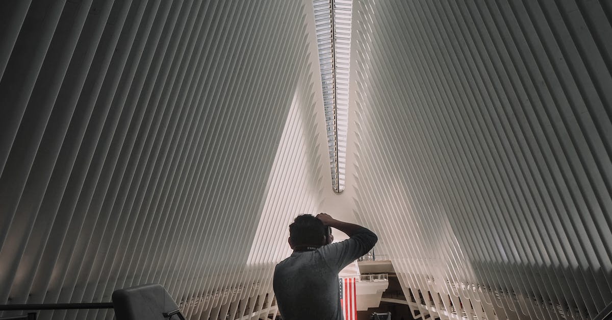 Stairwell inside The Met Manhattan - Back view of unrecognizable man standing and taking photo of contemporary World Trade Center Transportation Hub located in New York